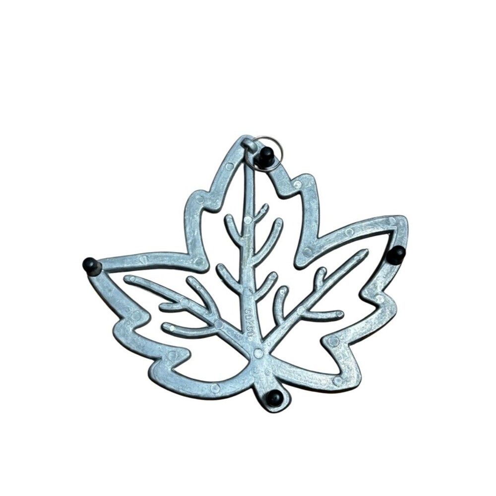 Copco cast aluminum heat resistant trivet featuring a maple leaf design. - Picture 2 of 4